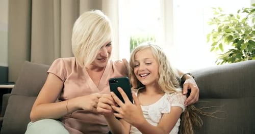Woman and Child Smiling Using Smartphone Together