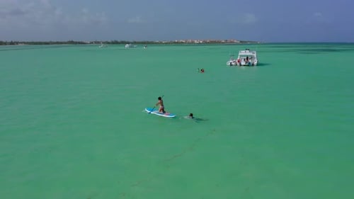 Die Menschen schwimmen und paddeln um Luxusyachten, die in der exotischen tropischen Dominikanischen Republik verankert sind