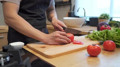 Person Cutting Tomatoes in a Bright Kitchen