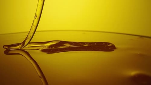 Honey Dripping Pouring Thick Stream on Yellow Background