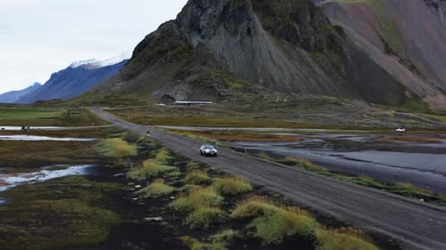 Drone Flight Of Car Driving Along Wet Dirt Track Road In Iceland