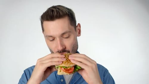 Young Adult Enjoying a Delicious Burger in Close Up