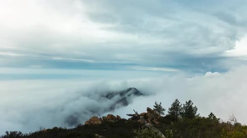 Wolken rollen über Berge und verwandeln sich in Nebel Zeitraffer