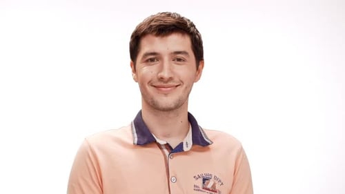 Junger gutaussehender Mann lächelt und zeigt sein Okay auf weißem Hintergrund in Zeitlupe