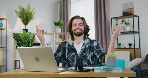 Man Meditating at Desk at Home