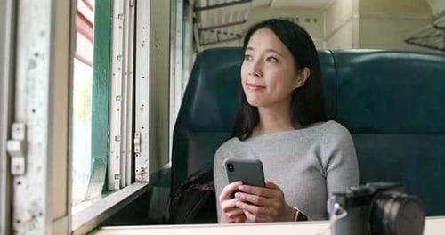 Femme regardant son téléphone portable et prenant le train