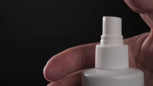 Closeup View of Human Hand and Spray Bottle Isolated on Black Parfume Moscito Spray Insects