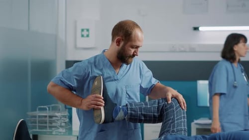 Physical Therapist Assists Patient with Leg Exercise