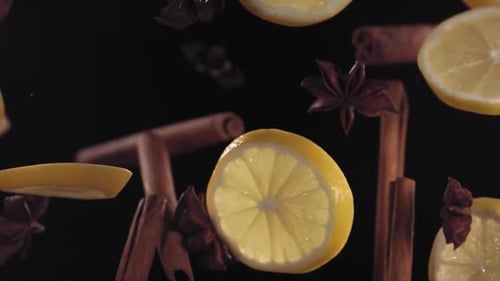 Floating Lemon Slices and Cinnamon Sticks on Black