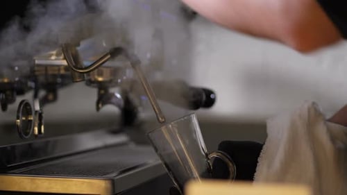 Close Up Barista's Hands Steaming Coffee Glass
