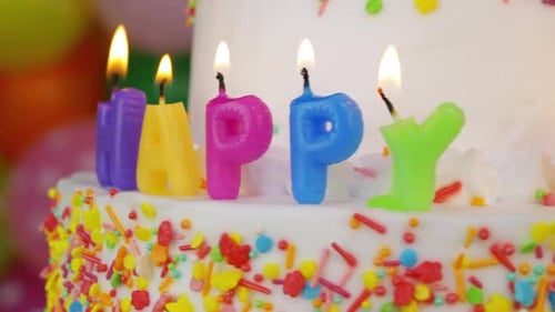 Festive Birthday Cake With Letter Candles and Sprinkles
