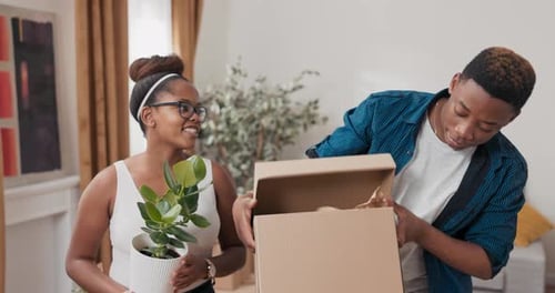 Couple Unpacking Moving Boxes in New Home