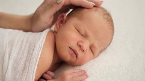 Gentle Hand Caressing Sleeping Newborn Baby
