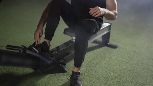 Bearded Sportsman Works Out in Gym with Rowing Machine Close Up