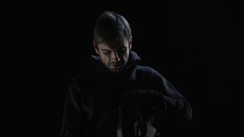 Young Man Puts On VR Headset in Dark Room