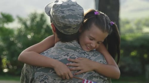 Emotional Reunion: Child Hugs Military Parent Outside