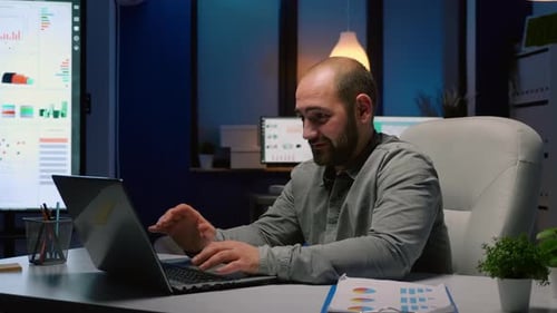 Man Working Late at Laptop in Office