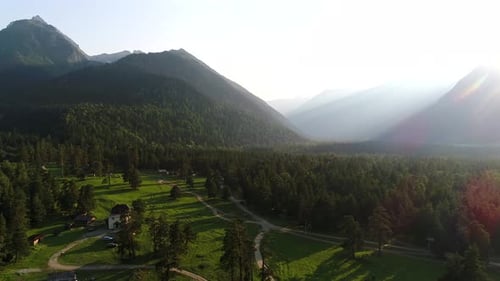 Forêt verte et montagnes sur fond de coucher de soleil ou d'aube