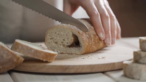 Ein Bäcker schneidet frisches aromatisches knuspriges Brot Nahaufnahme