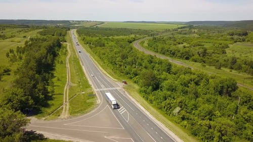 Aerial View of Highway Cutting Through Green Landscape