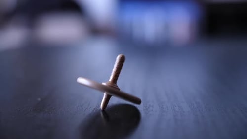 Spinning Top Toy Rotating on Dark Surface
