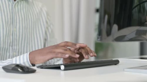 Close Up of African Man Using Mouse and Keyboard