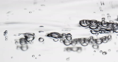 Blasen schwimmen zur Wasseroberfläche vor weißem Hintergrund