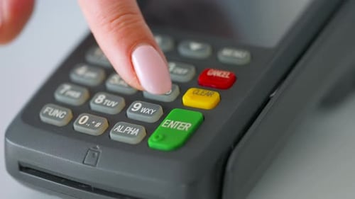 Finger Entering Numbers on Payment Terminal Close Up