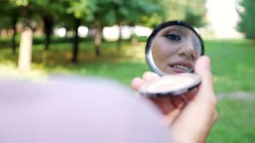 Elegant Young Woman in Pink Hijab Reflected in Small Mirror