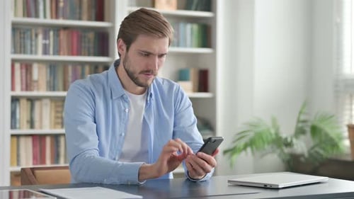 Attractive Man Using Smartphone in Office