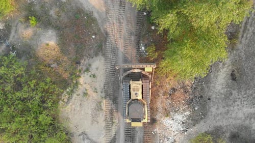 Top-Luftaufnahme von Bulldozer-Fahrten auf der Sandy Road auf der Baustelle