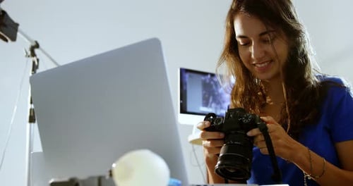 Woman Holding DSLR Camera in Studio Setting