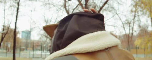 Man Walks Through City Park in Fall