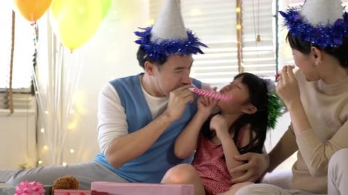 Happy Family Celebrating Birthday with Hats and Noisemakers
