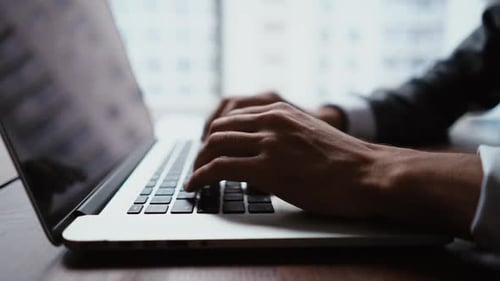 Close-up of Hands of Unrecognizable Business Man Typing on Laptop Keyboard Working at Office Desk