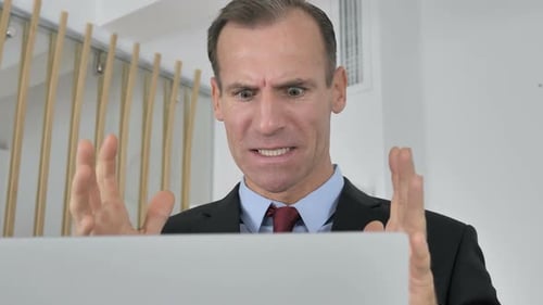 Frustrated Adult Man At a Laptop in Office