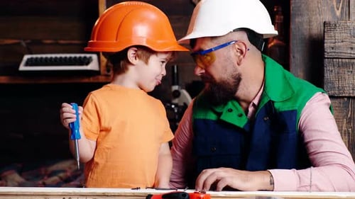 Child Learning Use Tools with Dad. Parent in Protective Helmet Teaching Little Son To Use Different