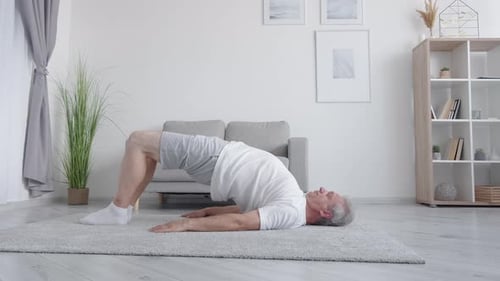 Mature Man Doing Glute Bridge Exercise at Home
