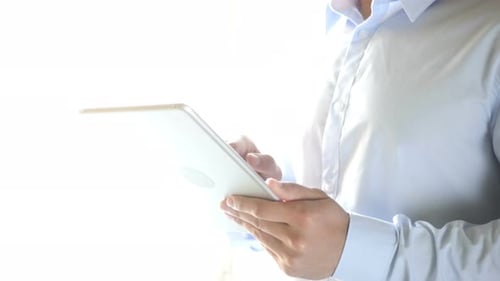 Man Uses Tablet For Technology, Communication Indoors