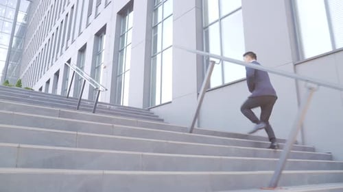 Man Runs Up Stairs Outside Modern Office Building
