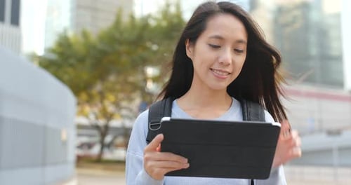 Woman Uses Tablet in City with Skyscrapers