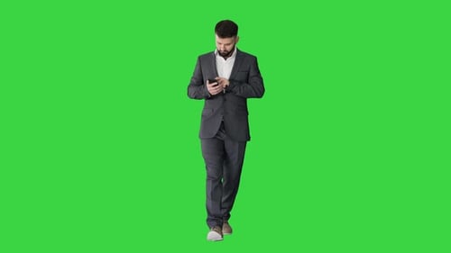 Businessman Walking and Using the Phone on a Green Screen, Chroma Key.