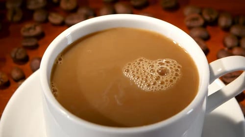 Milk being poured into a cup of coffee