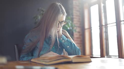 Woman Reading Book in Home by Window