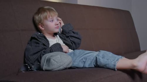 Boy Talking on Phone While Sitting on Couch