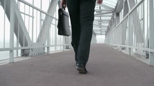 Businessman Walking on Walkway Carrying a Briefcase