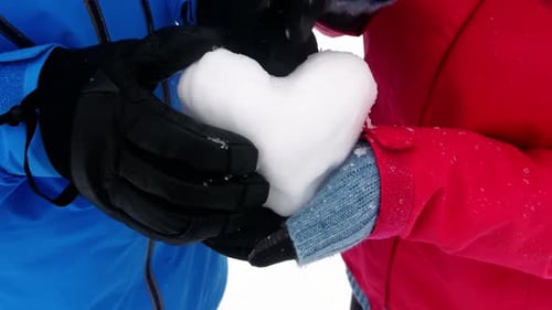 Loving Couple Holds Snow Heart in Winter