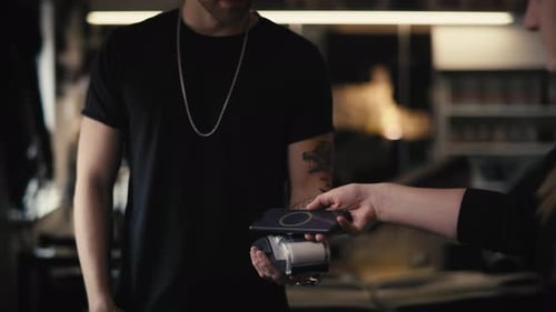 Homme caucasien payant dans un studio de tatouage. Tourné avec une caméra à hélium RED en 8K.