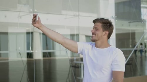 Man Taking Selfie in Front of Glass Building