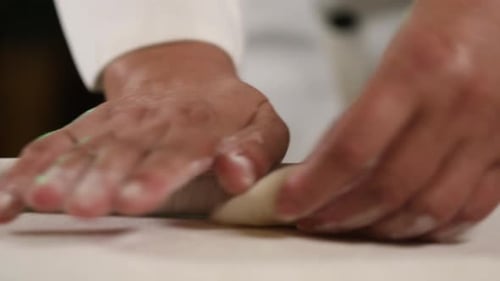 Hands Rolling Dough with a Rolling Pin